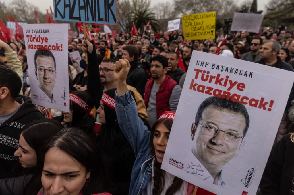 Protesters hold posters of Ekrem İmamoğlu reading “Türkiye kazanacak” at a rally in Istanbul.